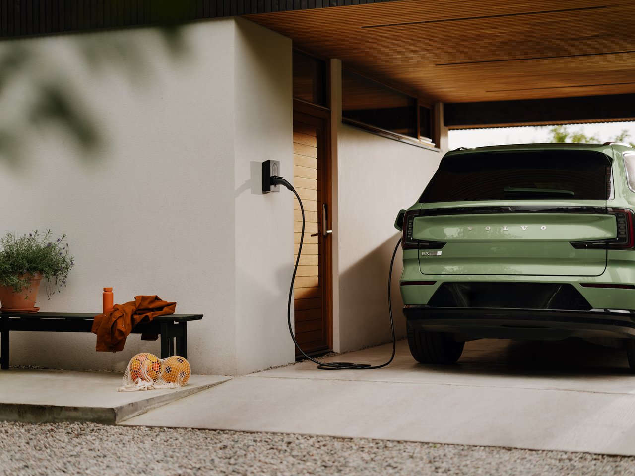 Zaptec Go hjemmelader på husvegg som lader firmabil